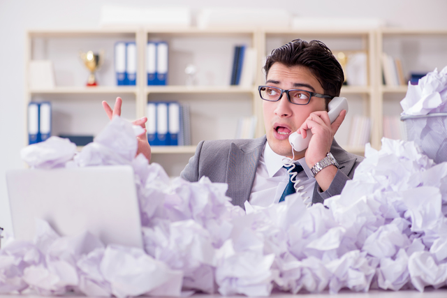 Businessman in paper recycling concept in office